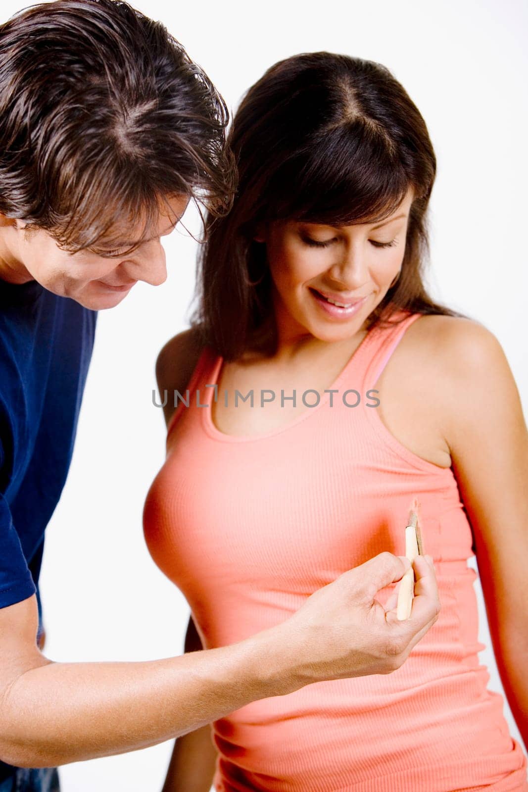 Mid adult man painting on a young womanŽs top with a paintbrush
