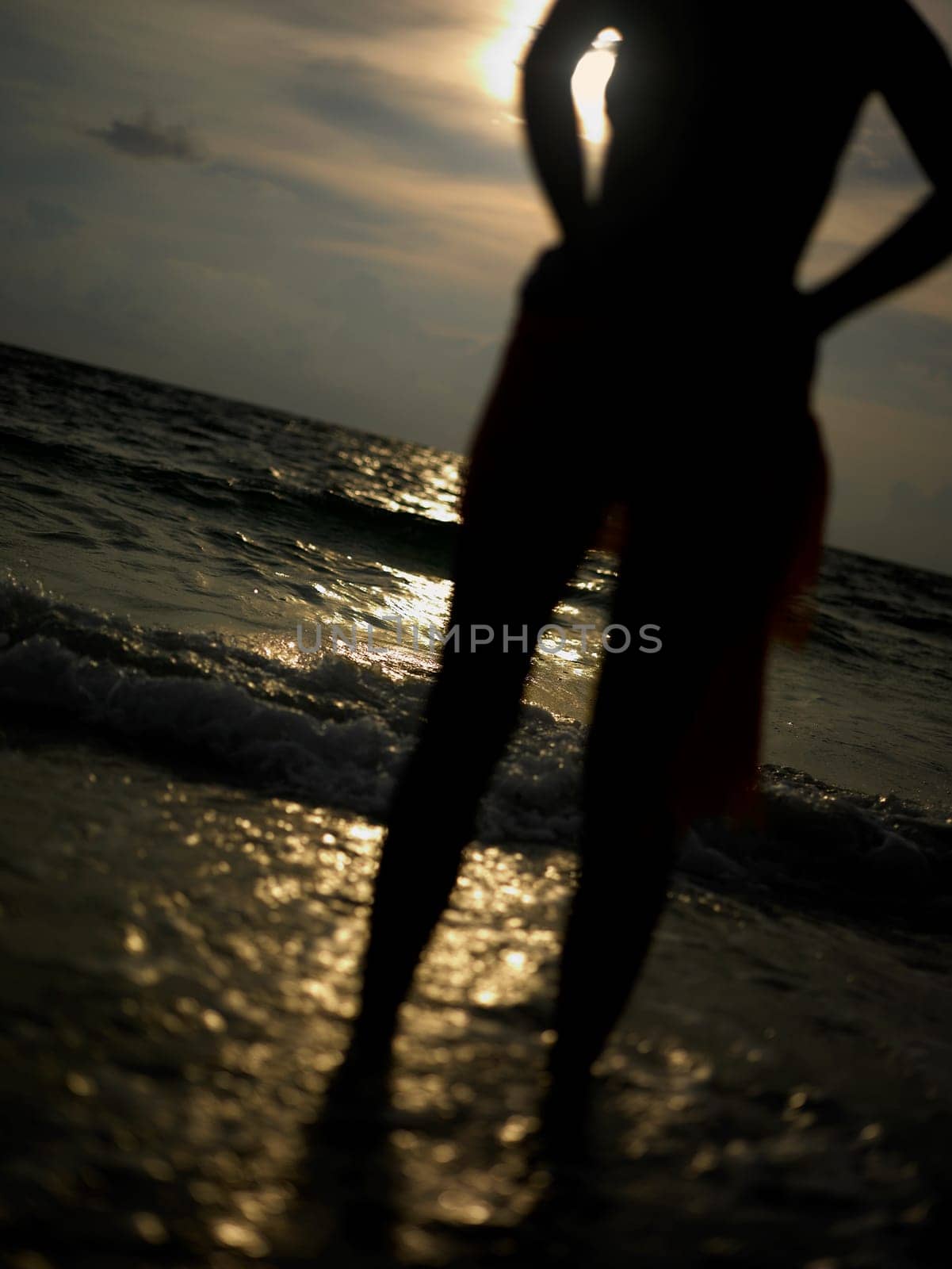 Silhouette of a young woman standing on the beach