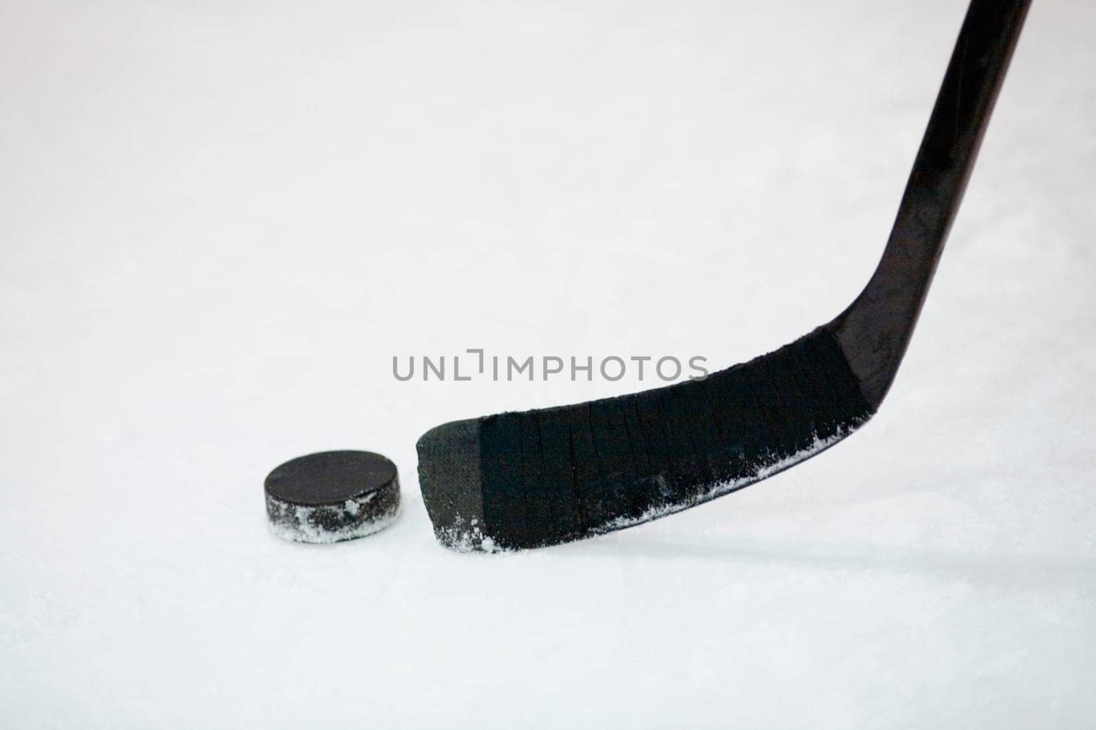 Close-up of an ice hockey stick with a hockey puck