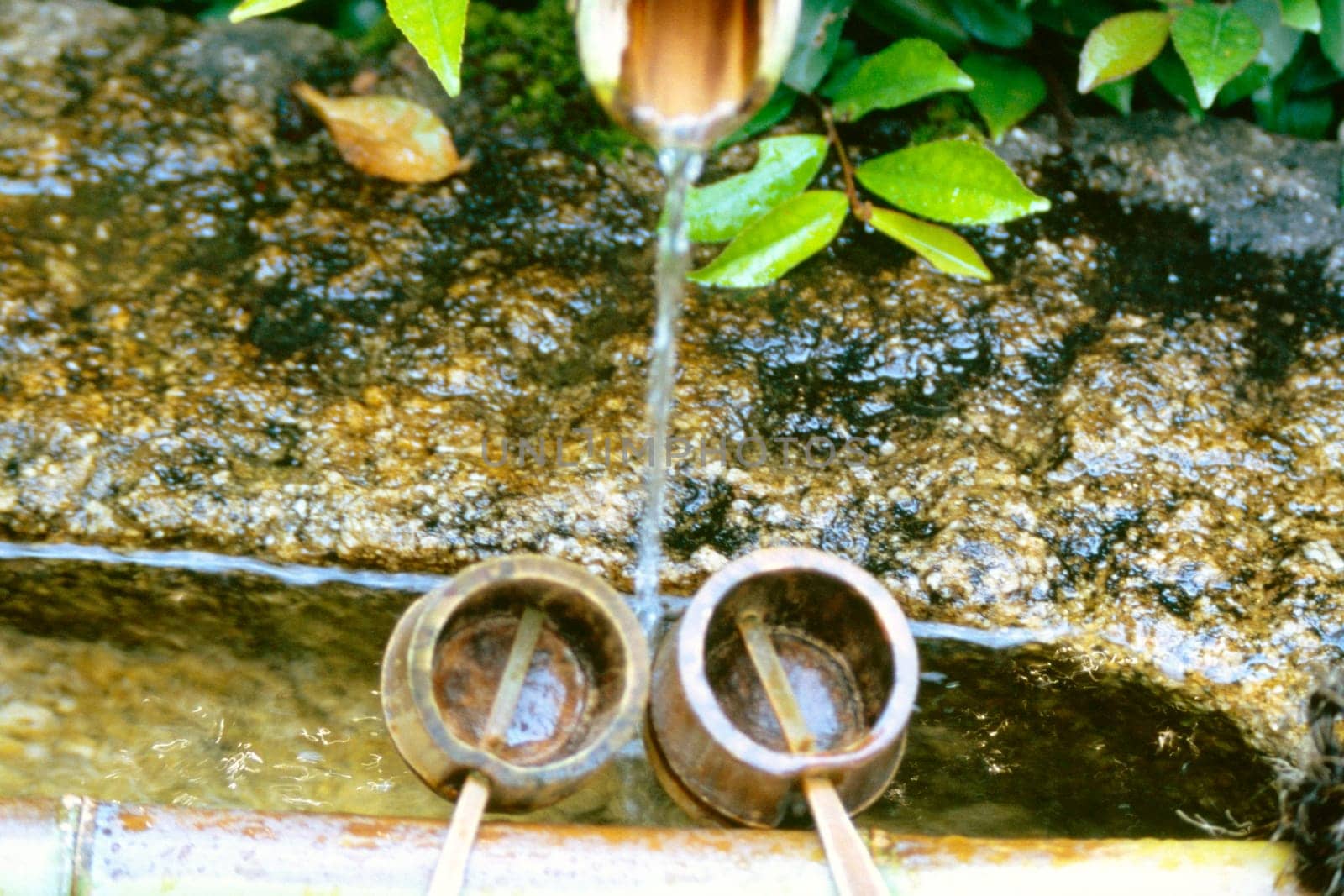 High angle view of water flowing from a pipe into the buckets, Ryoanji Temple, Kyoto, Japan