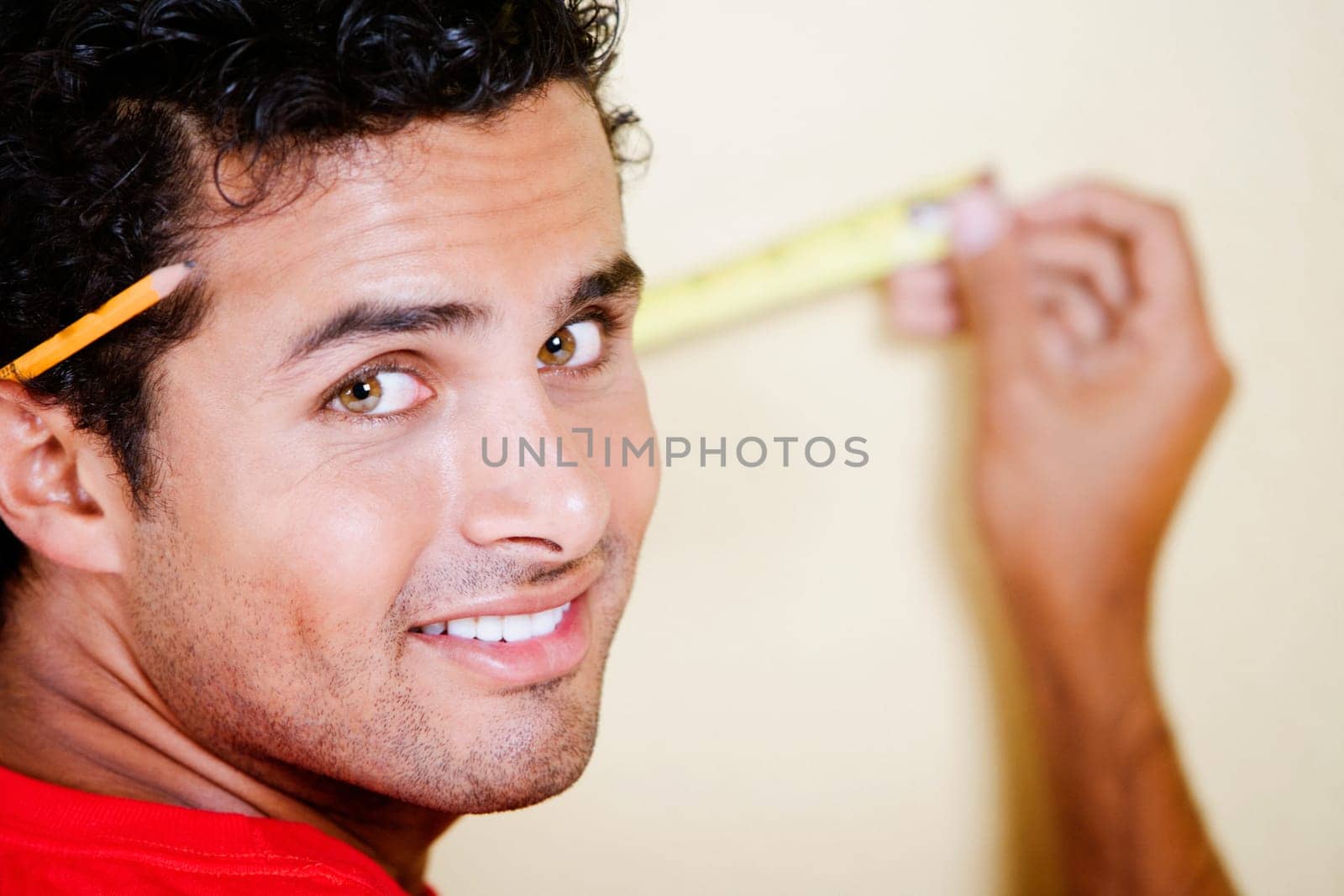 Portrait of a young man measuring with a measuring tape