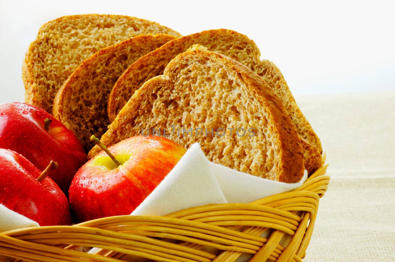 Close-up of apples and brown bread in a basket