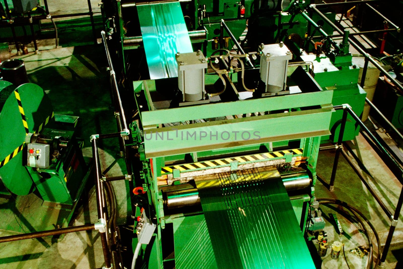 High angle view of stainless steel sheet being rolled in a steel mill