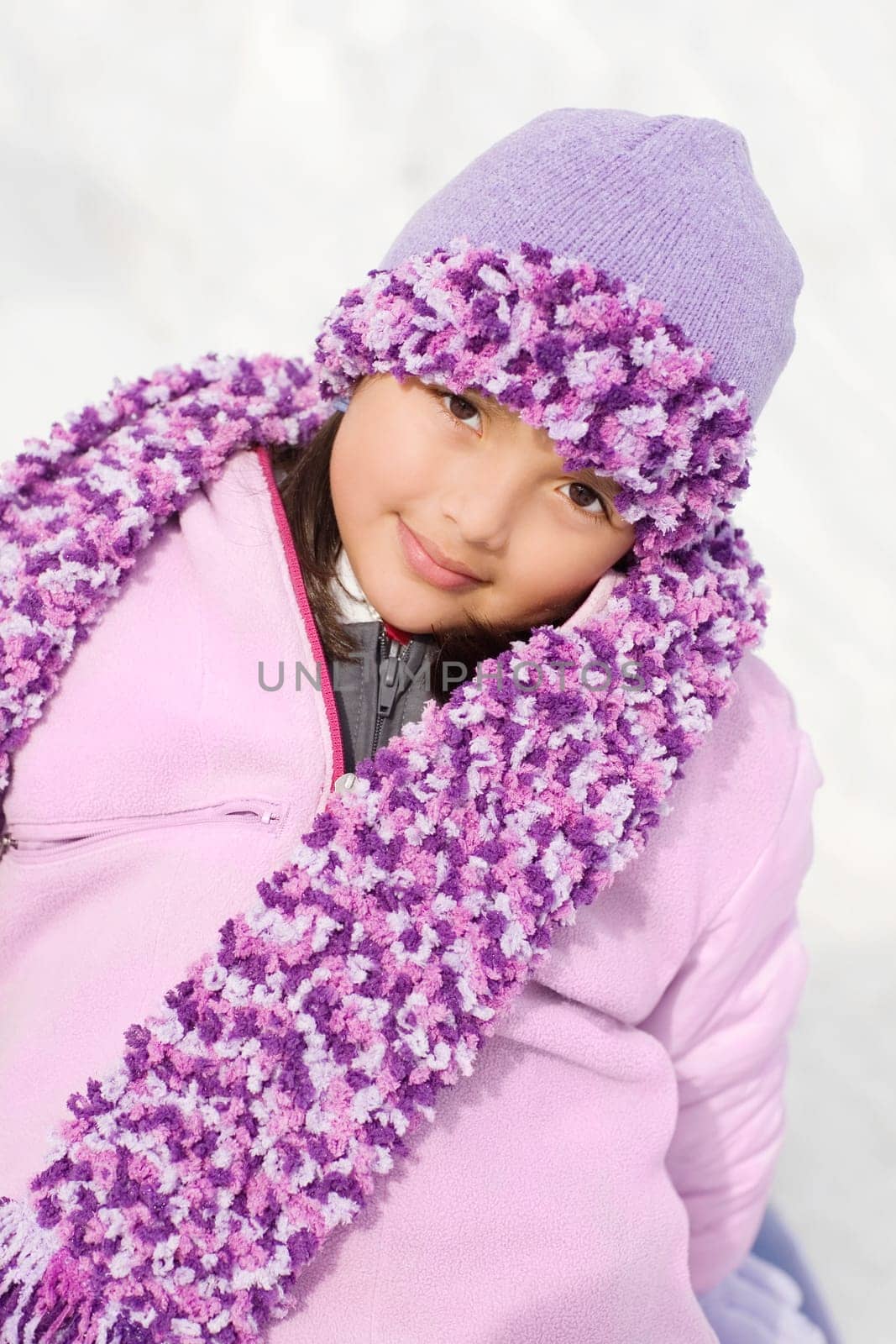 Portrait of a girl sitting in snow and smirking