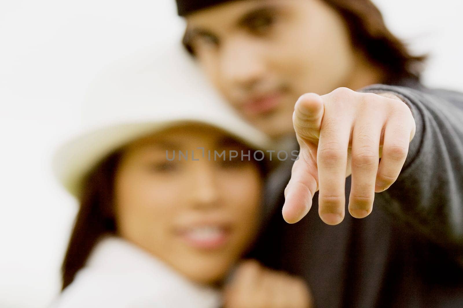 Close-up of a young man and a young woman pointing