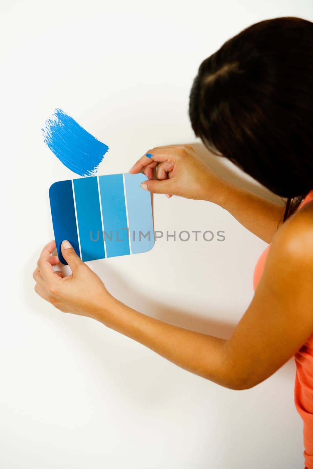 Woman holding a color swatch against a wall
