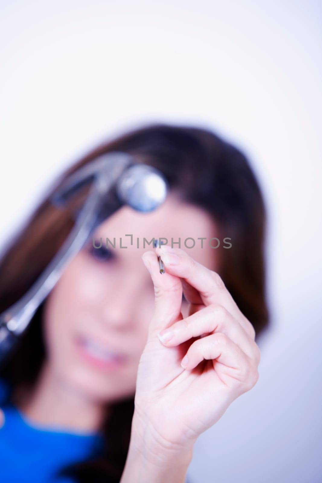 Portrait of a young woman holding a hammer and a nail