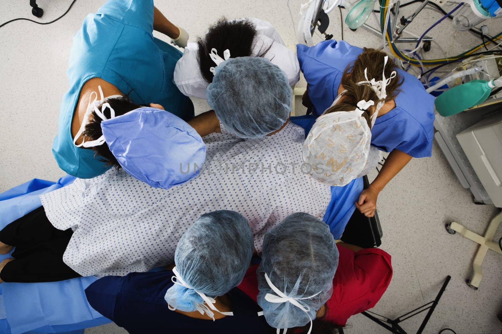 High angle view of five surgeons operating a patient
