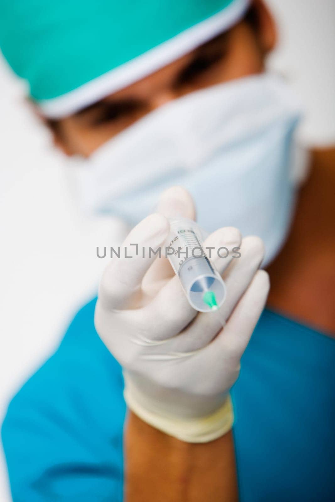 Close-up of a male surgeon holding a syringe