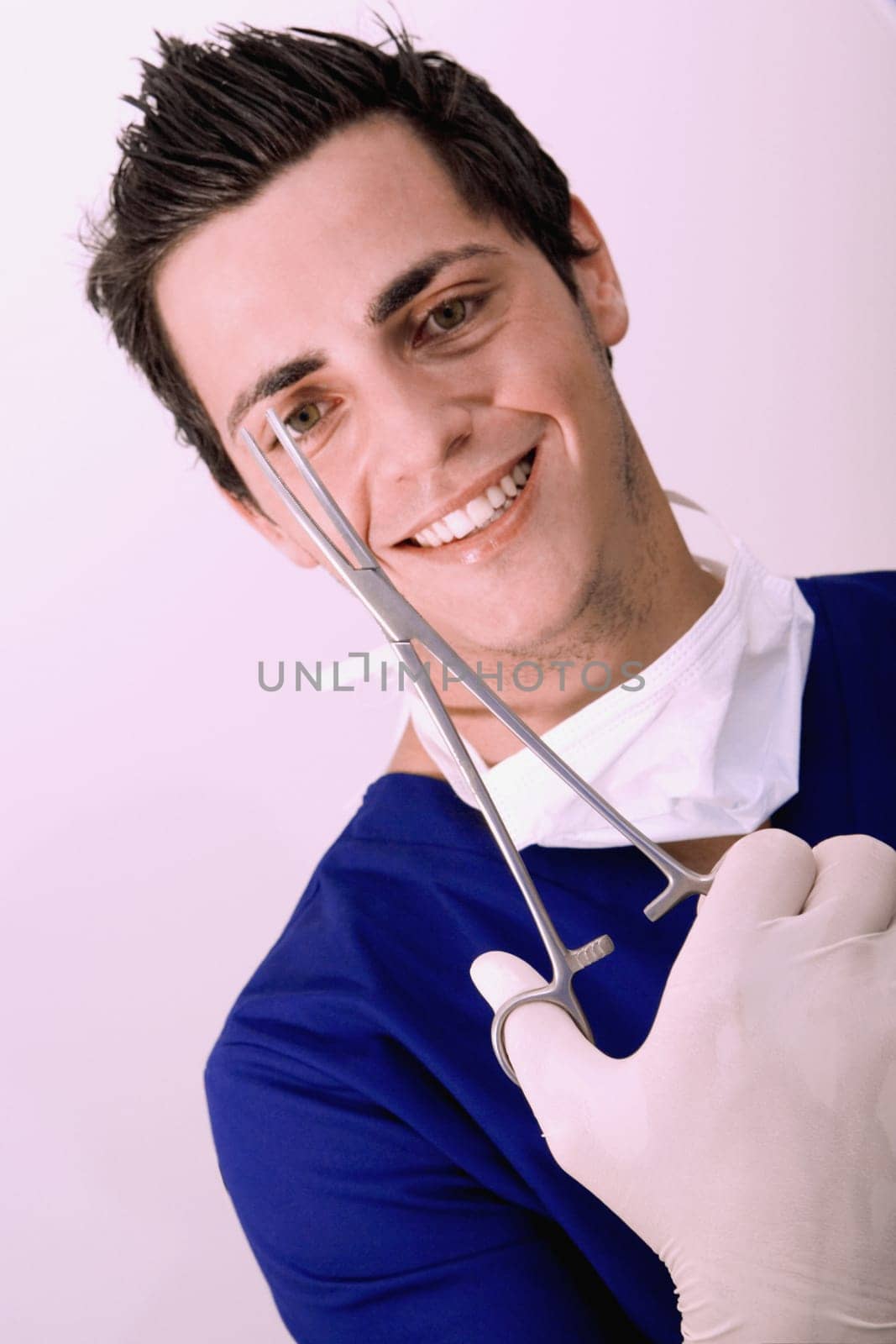 Portrait of a male surgeon holding a surgical scissors and smiling