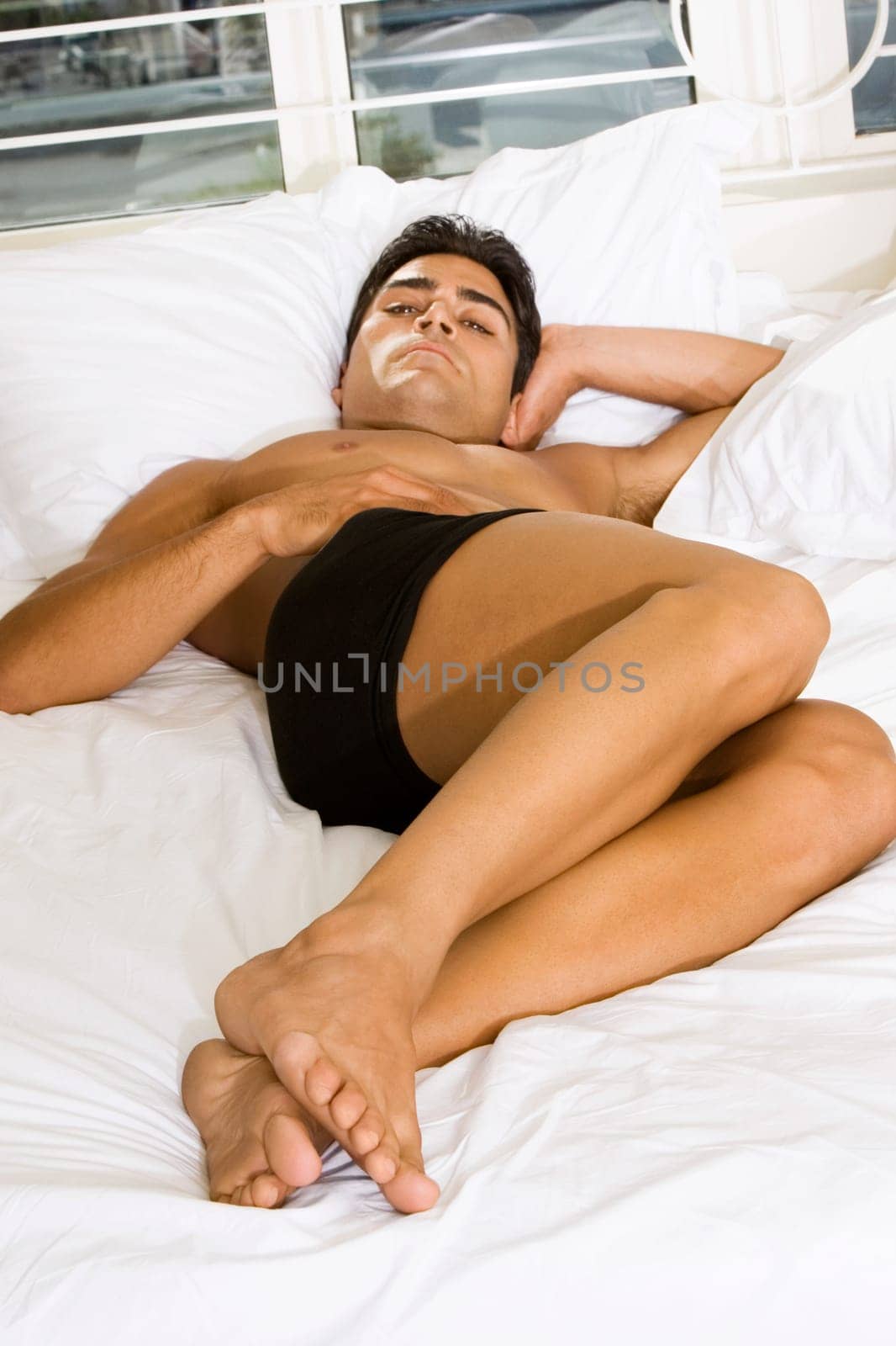 Portrait of a young man lying on the bed