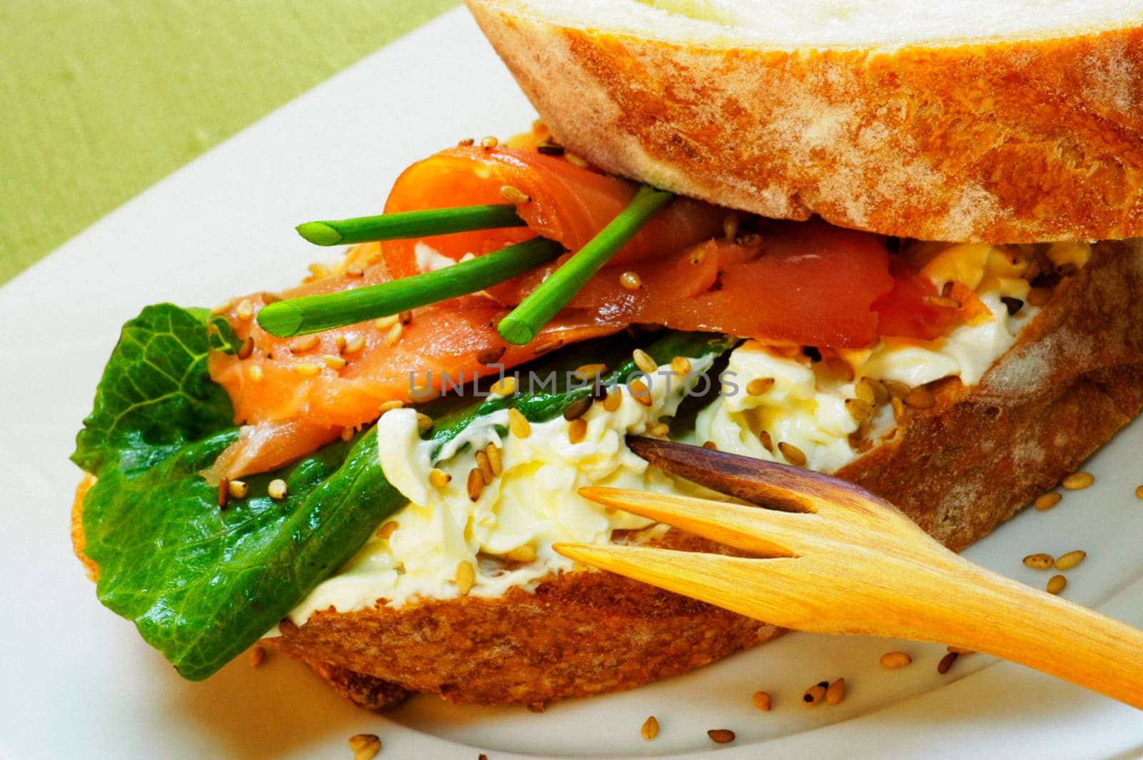 Close-up of a ham sandwich with a fork on a plate