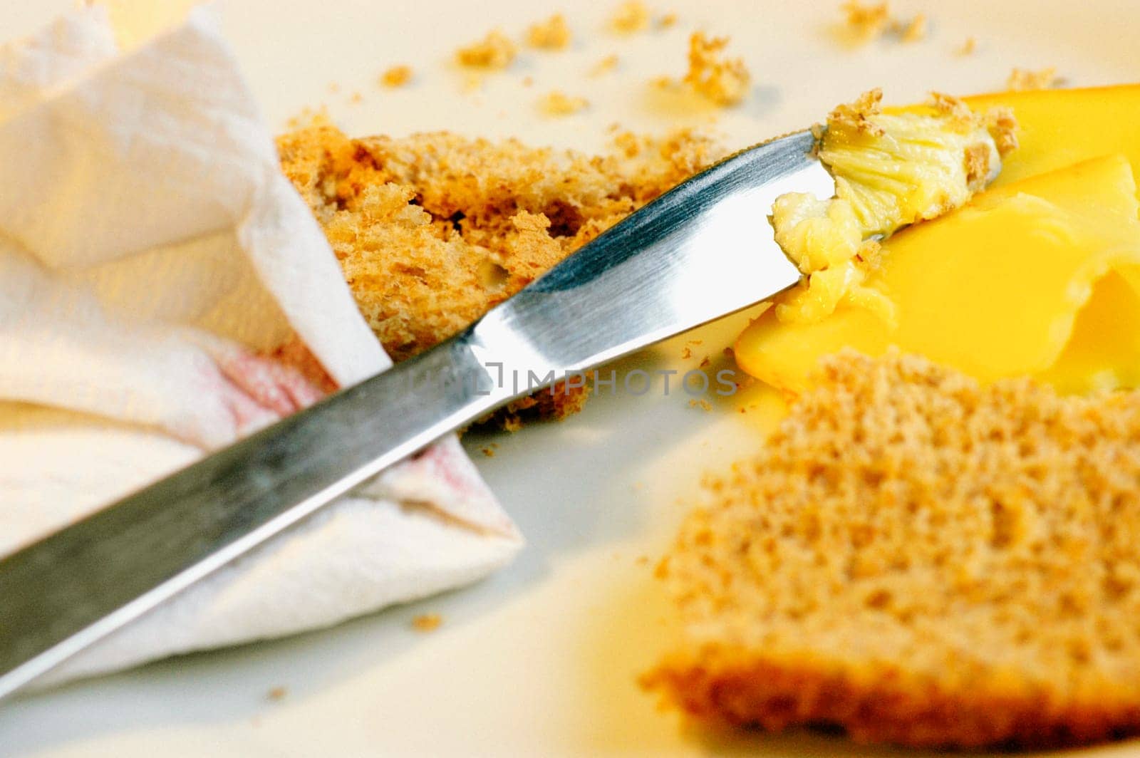 Close-up of a table knife with brown bread and cheese