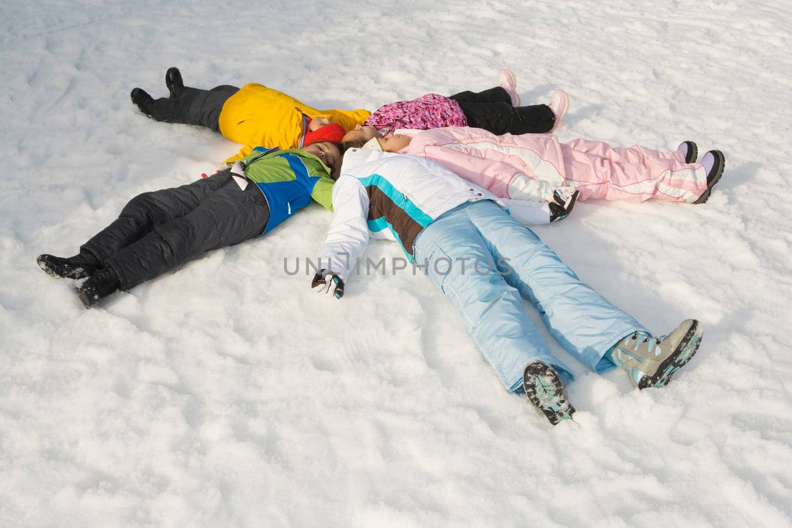 High angle view of five children lying on snow