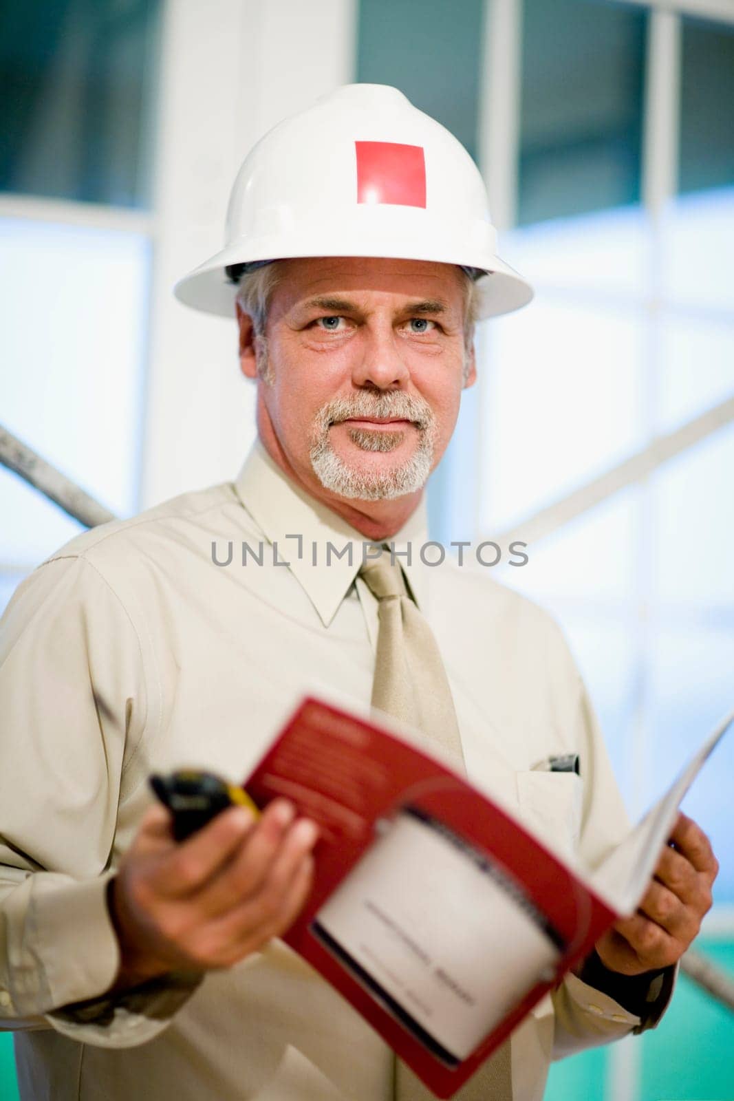 Portrait of a male architect holding a walkie-talkie and a color swatch