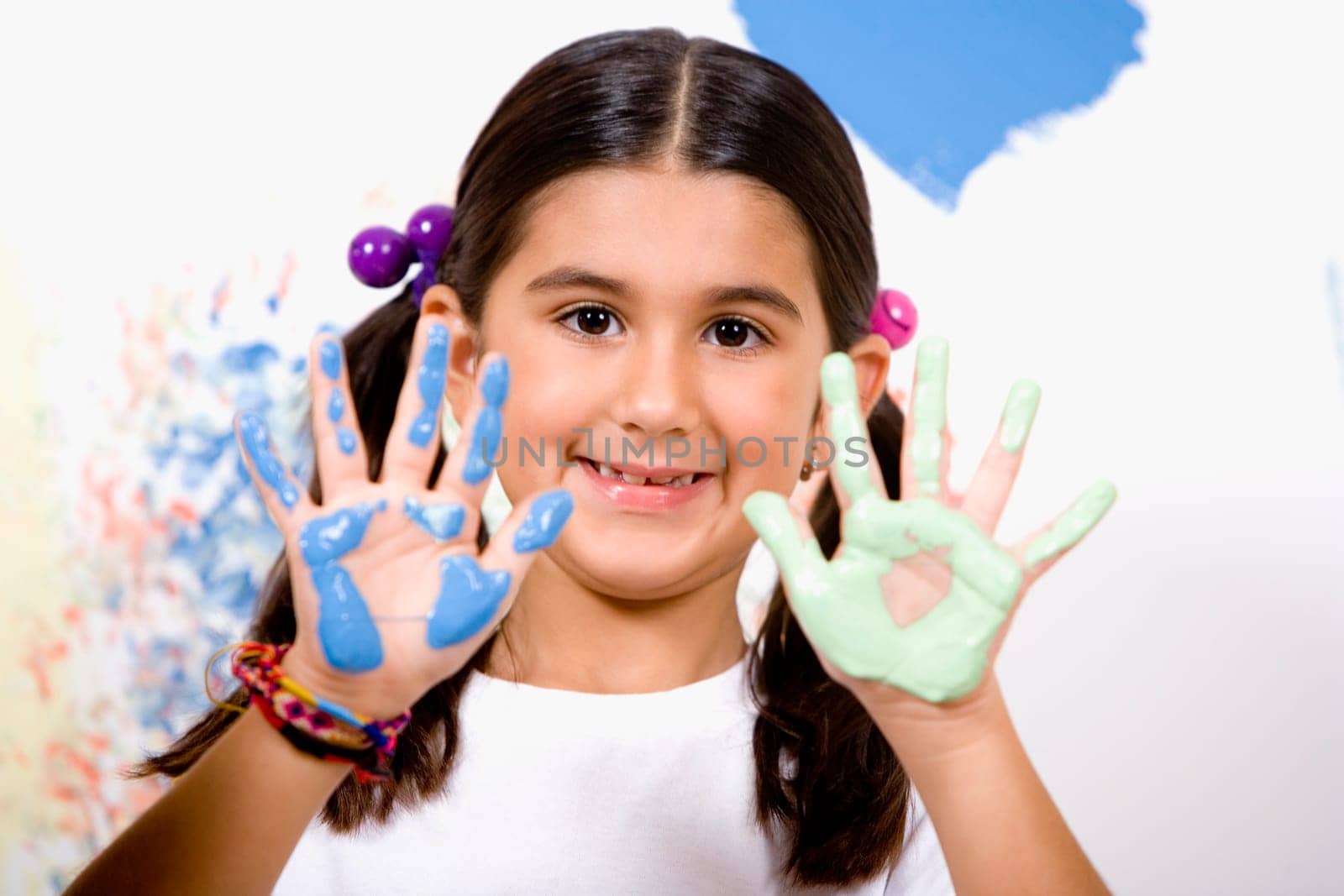 Portrait of a girl showing paint on her palms with her father smiling