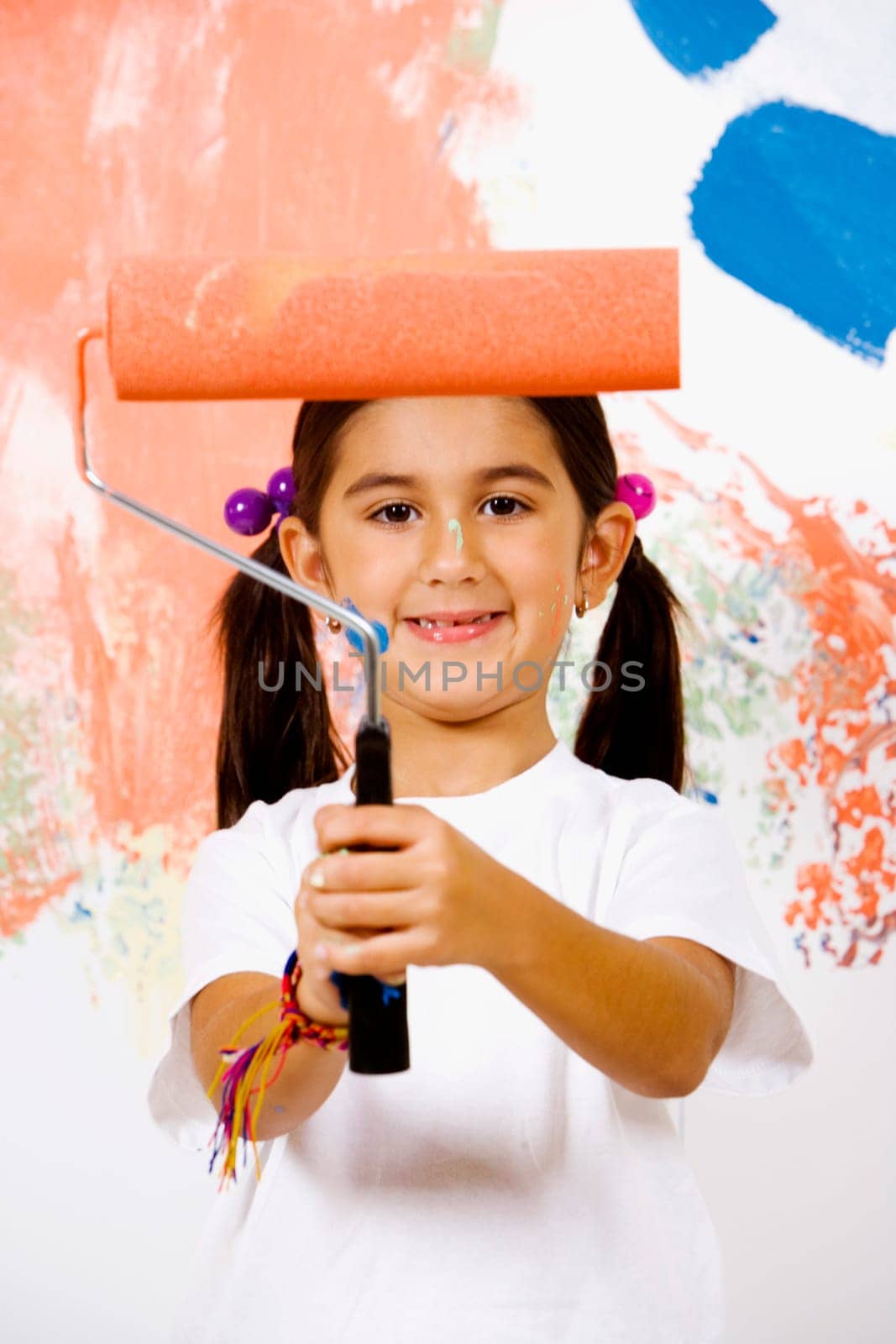 Portrait of a girl holding a paint roller and smiling