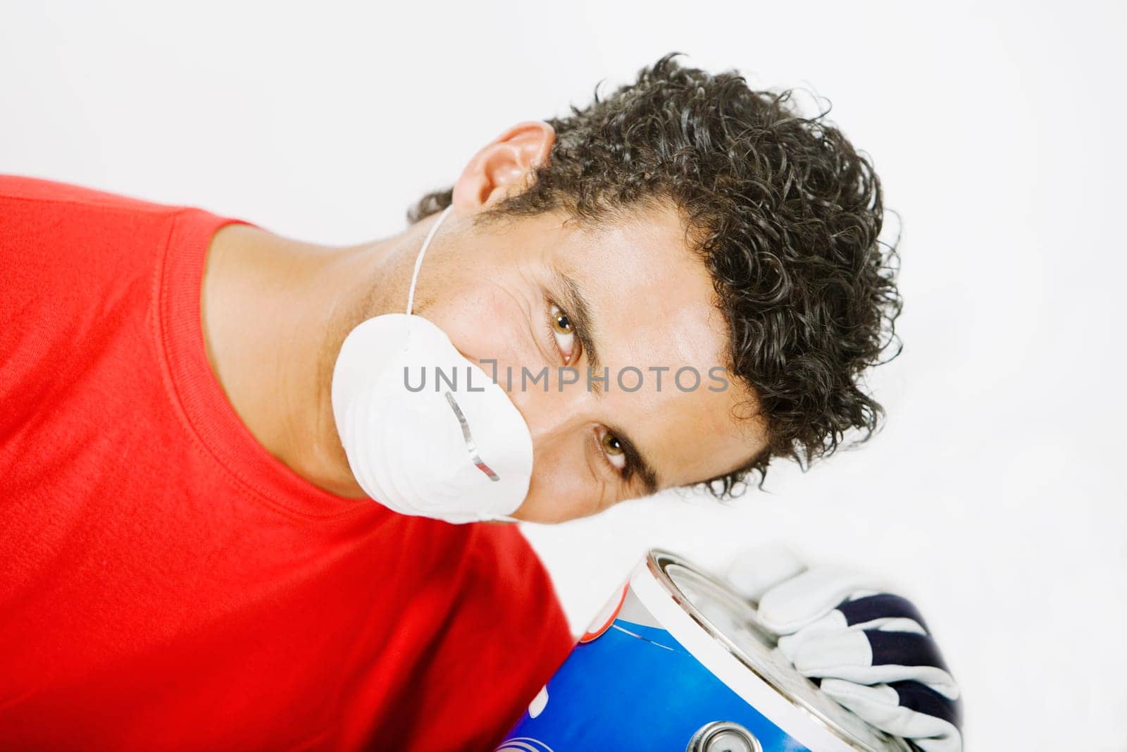 Portrait of a young man wearing a pollution mask and holding a paint can