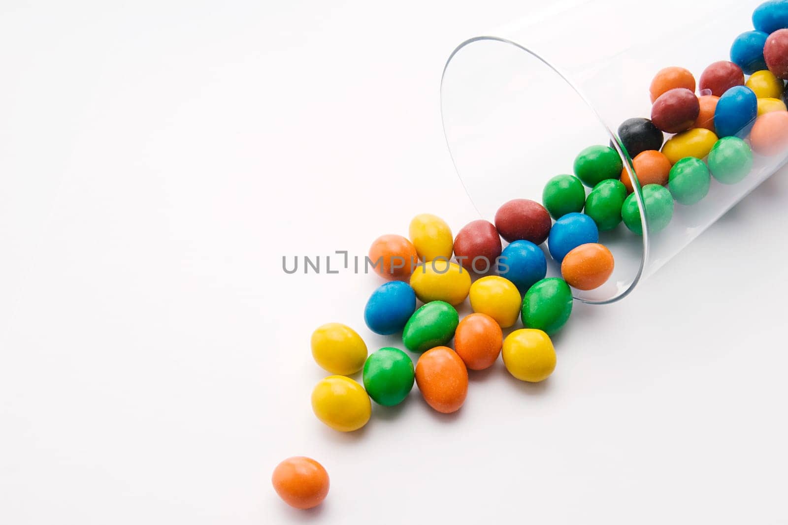 Close_up of candies spilling from a glass