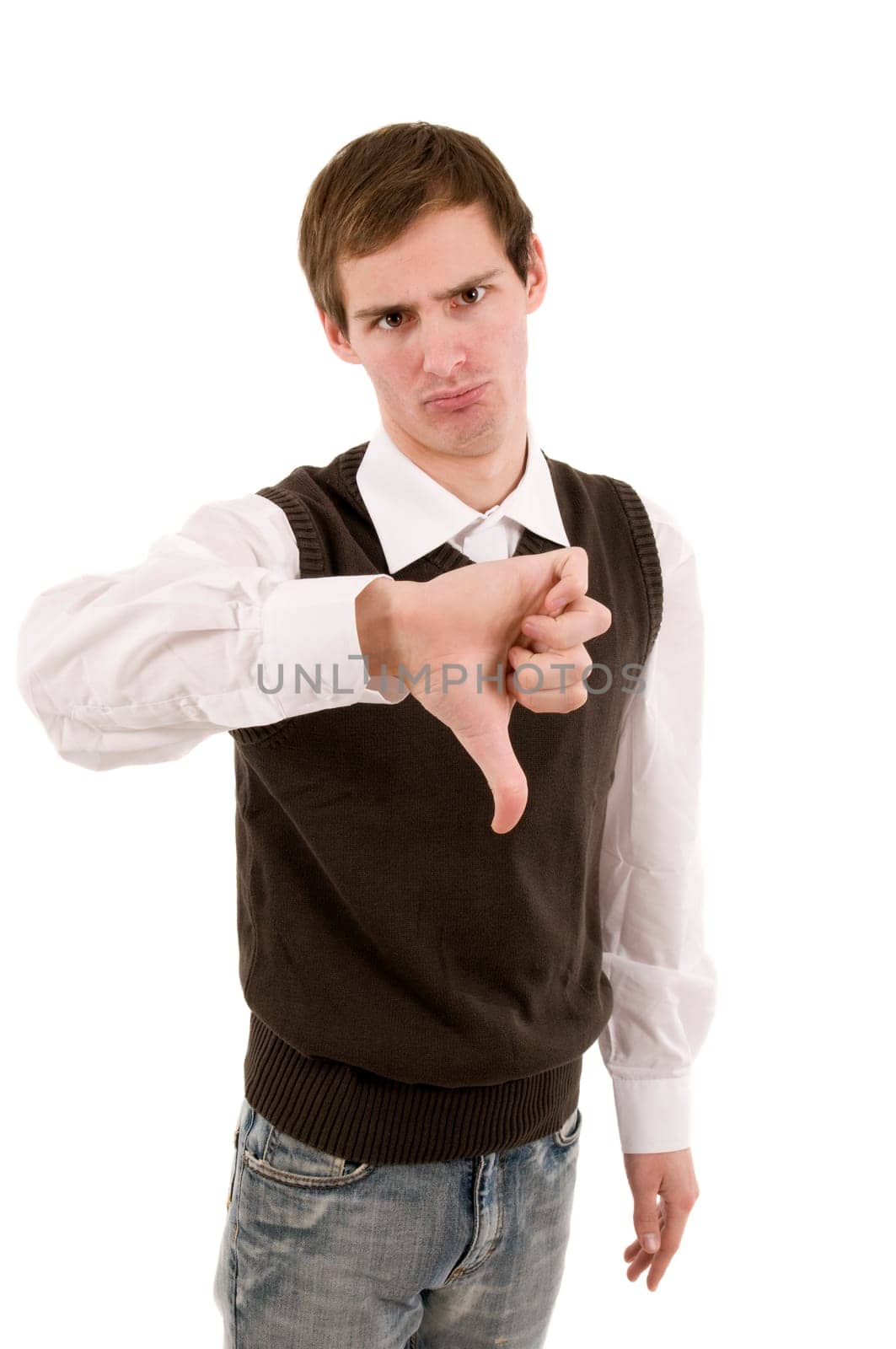 Frontal torso shot of a young man showing the thumb of his right hand down and looking negative at the camera against white background.