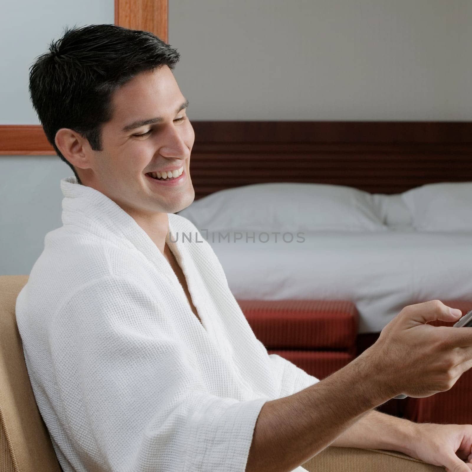 Side profile of a young man holding a remote control and smiling