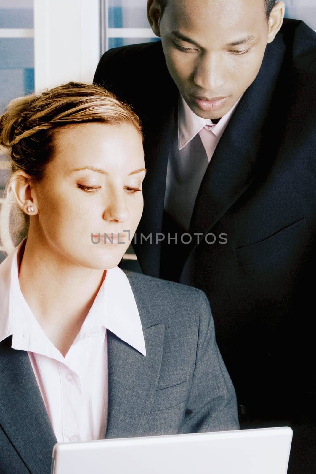 Close-up of a businessman and a businesswoman looking at a laptop