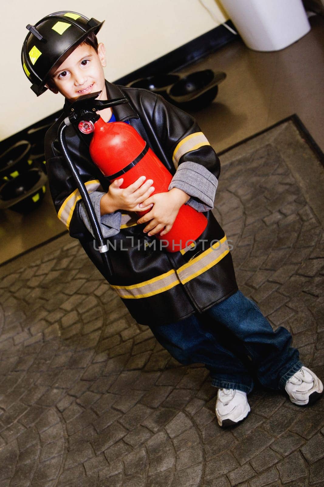 Portrait of a boy standing in a fireman costume