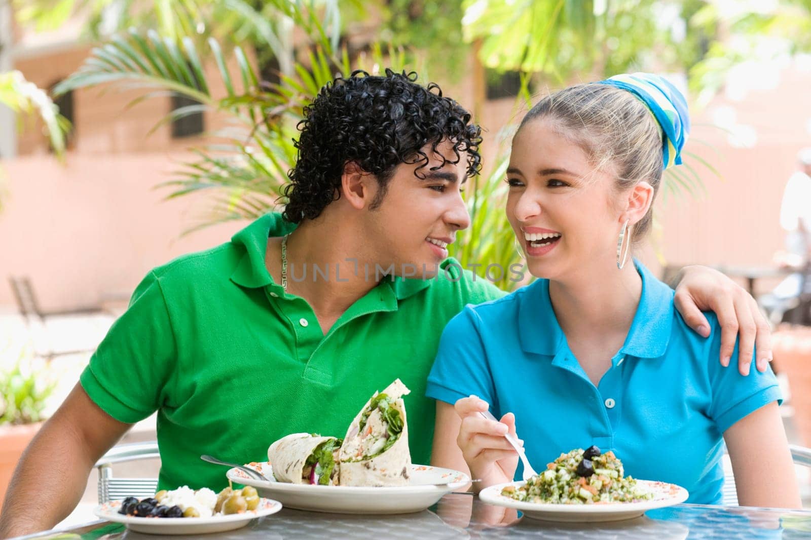 Close-up of a young man and a teenage girl sitting at a table in a restaurant