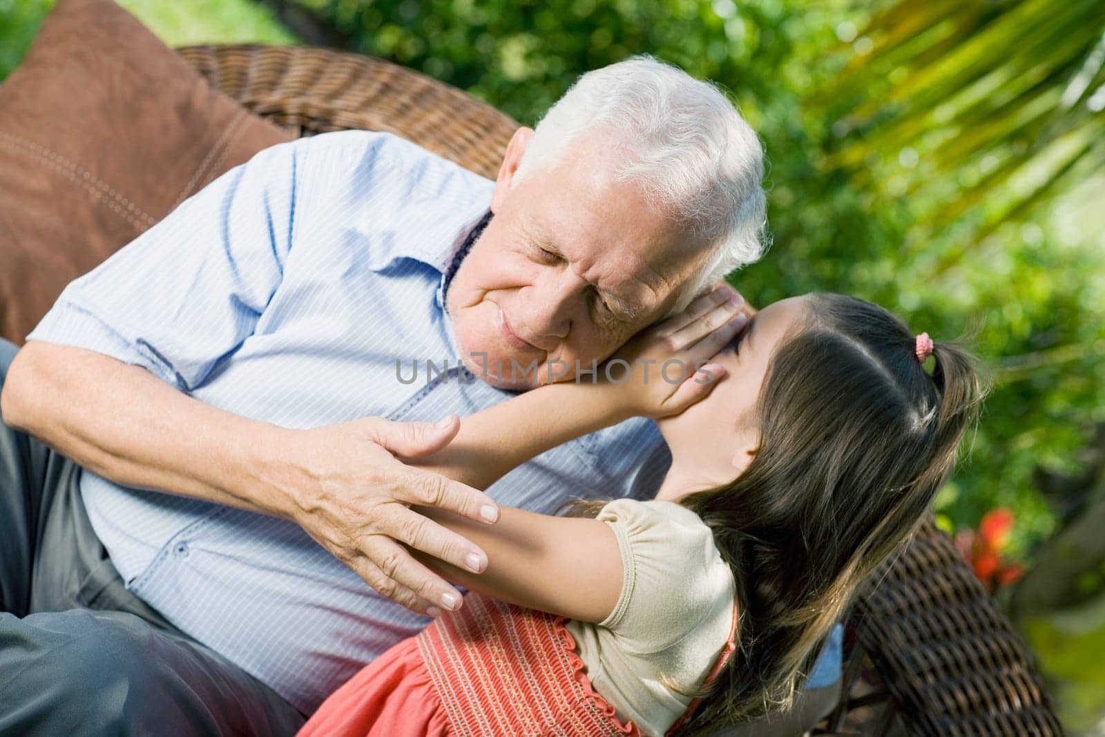 Girl whispering into her grandfatherŽs ear