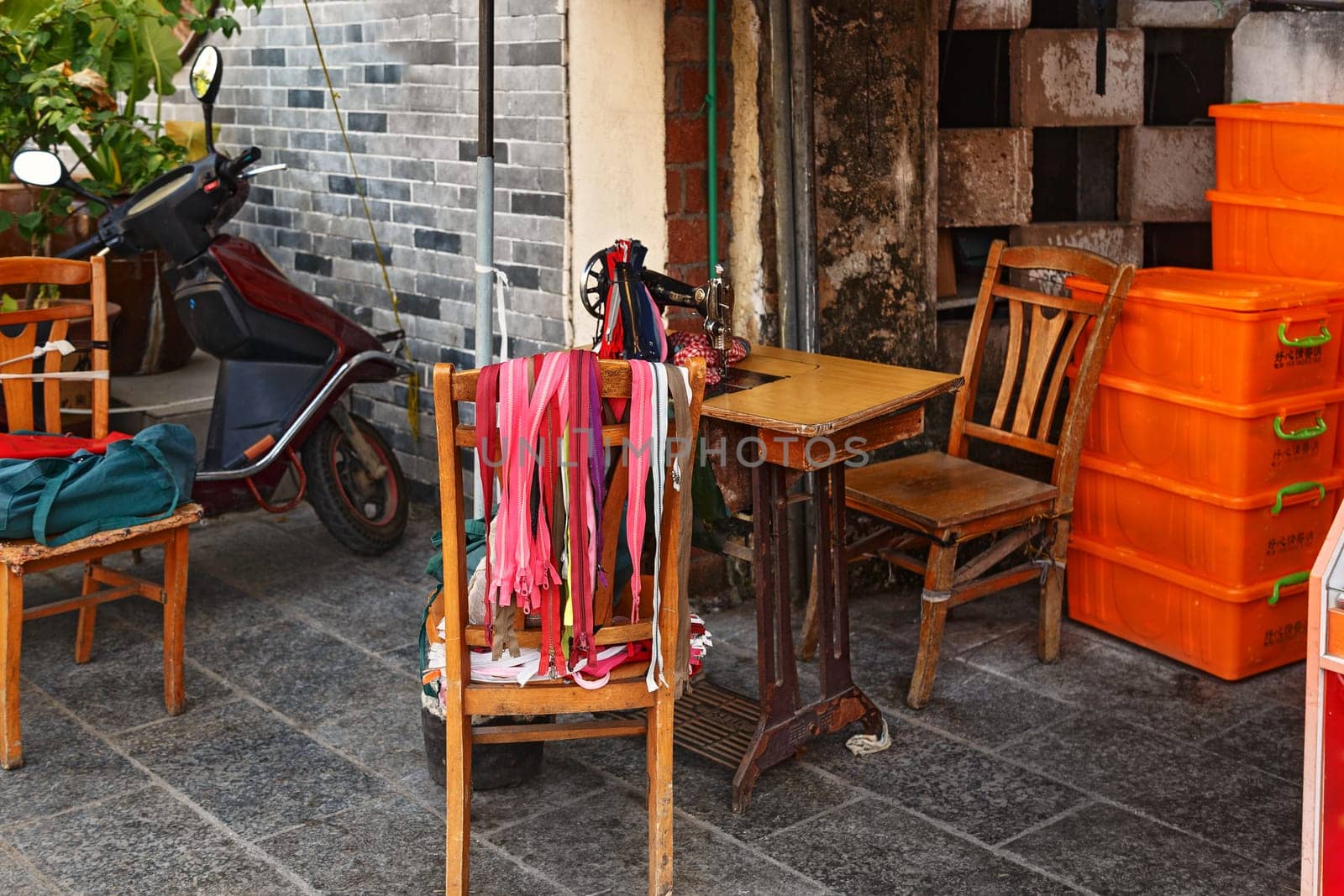 Chair with many multi-colored locks for clothes, street sewing workshop in China, Guilin Aug 24, 2019