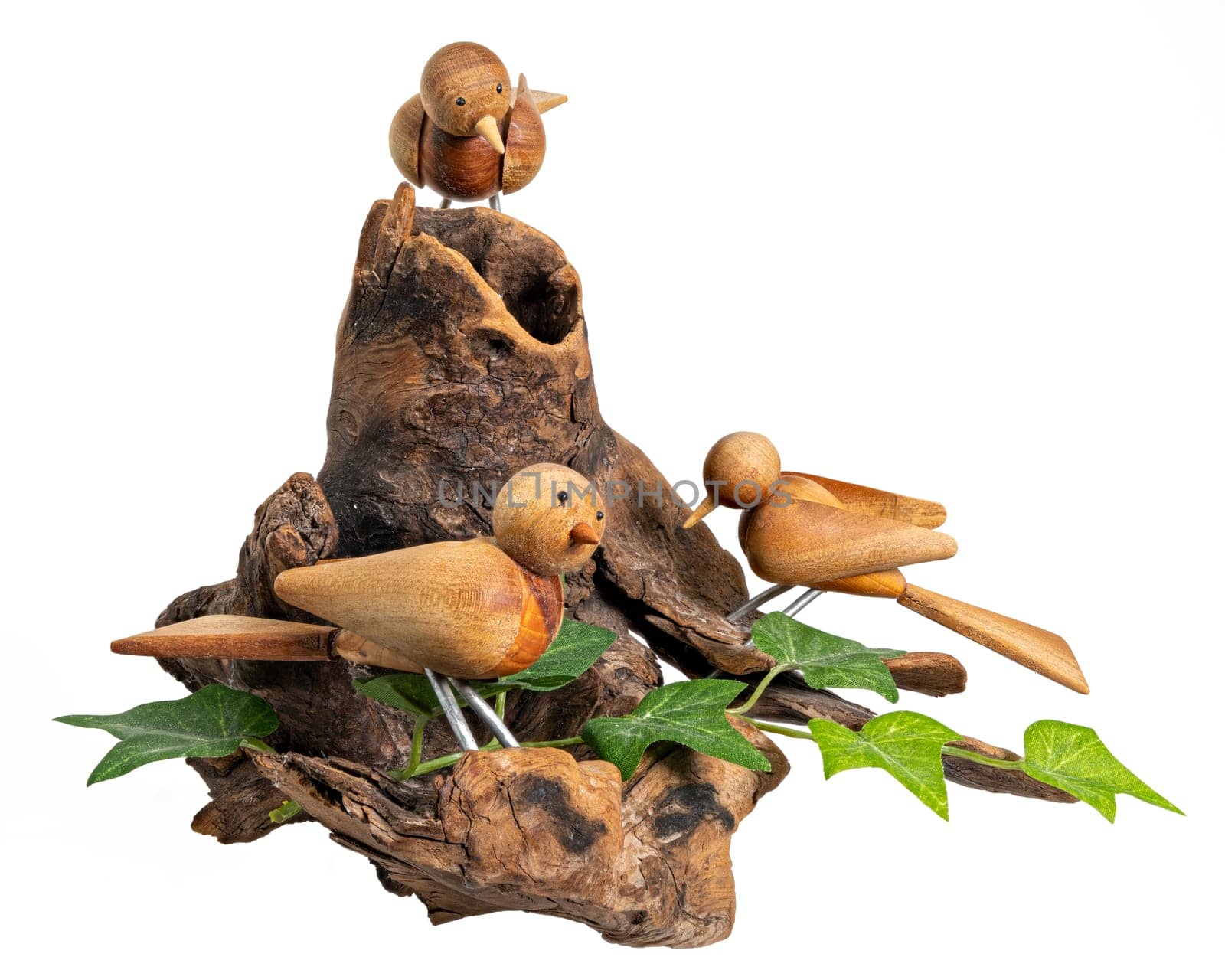 Wooden model with 3 turned birds on a tree root, isolated on white