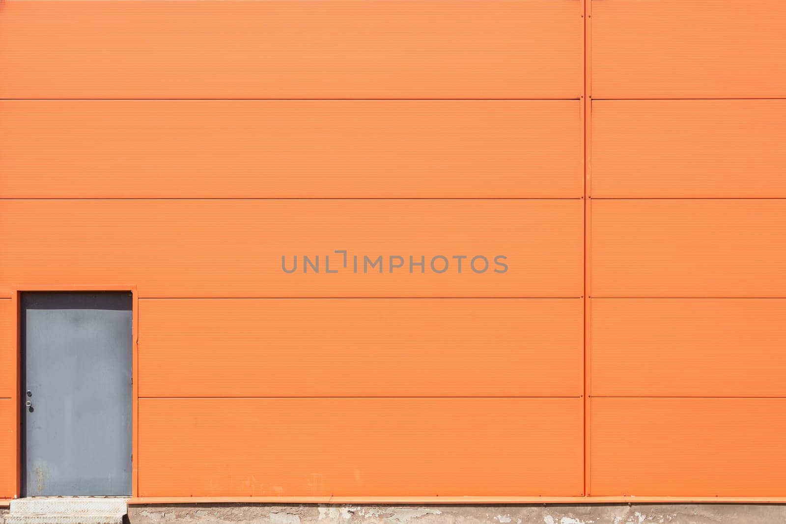 Modern orange building wall with metal doors