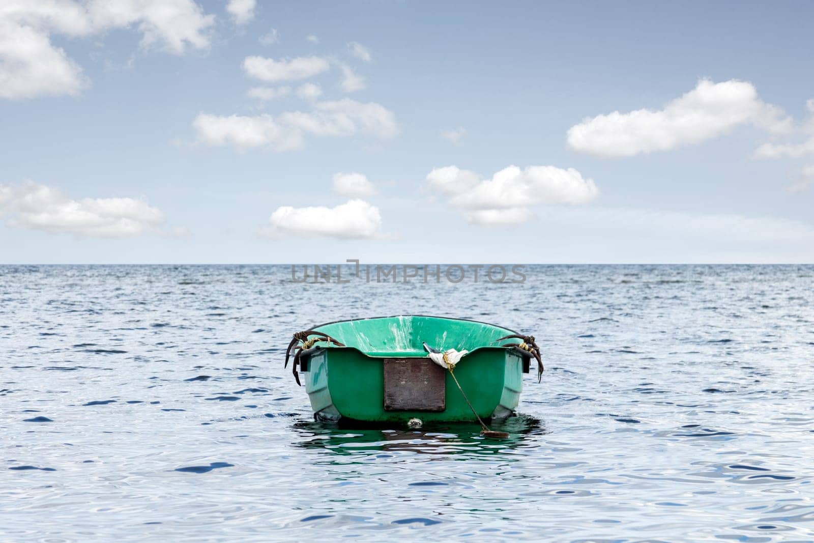 Empty wooden boat floating out to sea