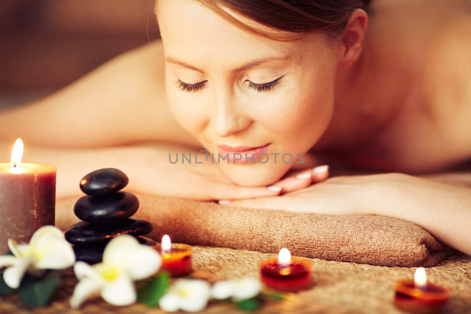 Woman relaxing among candles and flowers