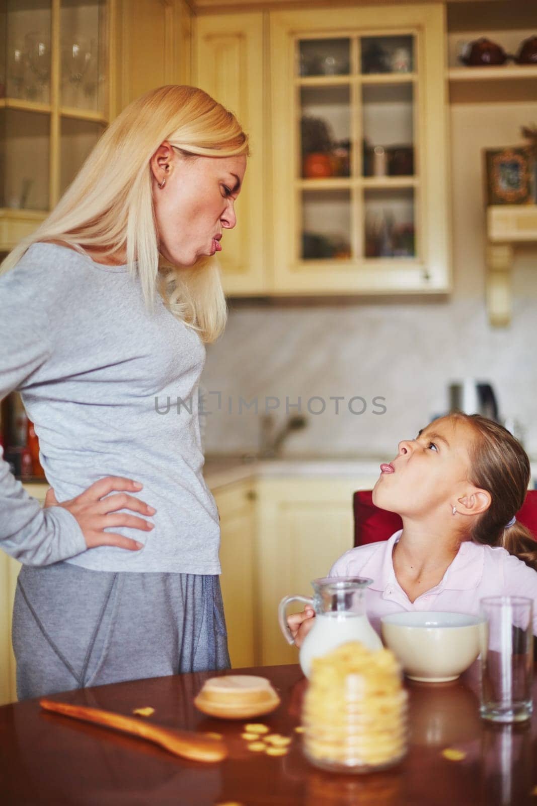 Mother and daughter making face at each other