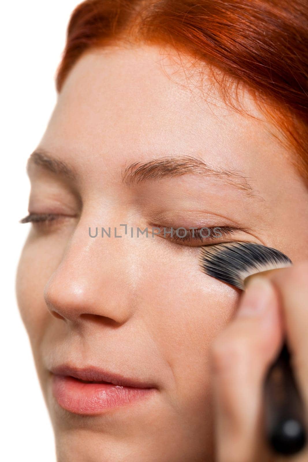 Young pretty woman with red hair wears makeup on nak shot portrait isolated against white background