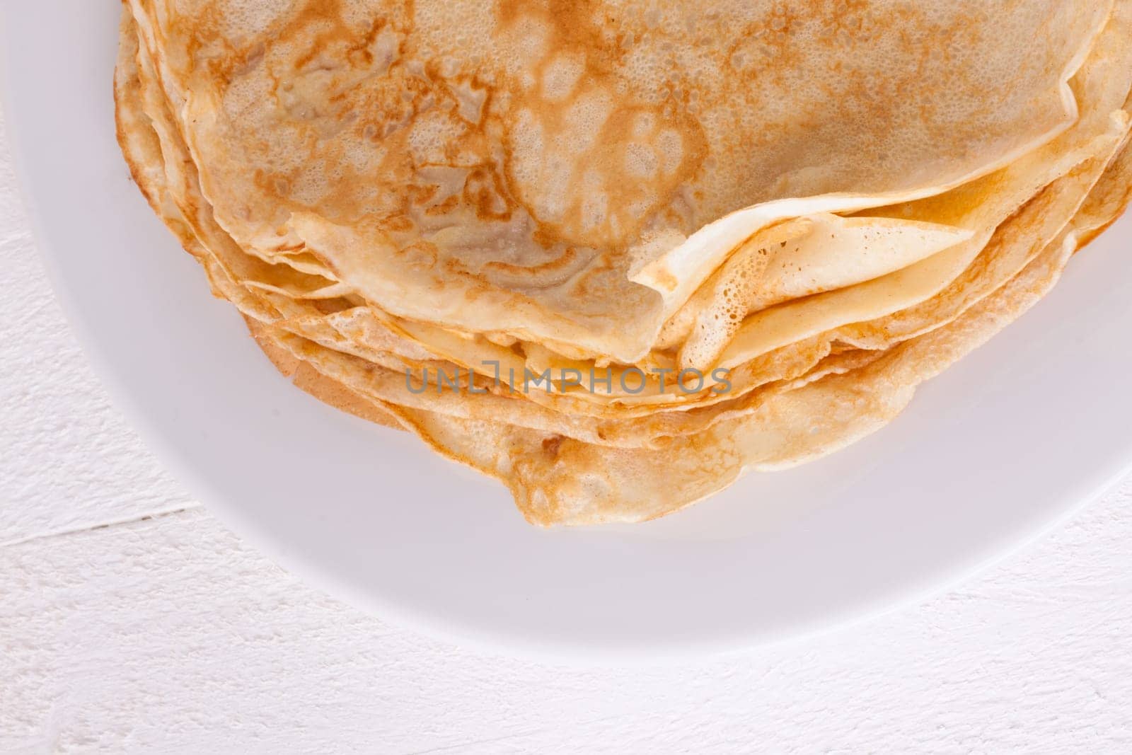 delicious fresh crepes pancakes pancakes on a white plate on a rustic white wooden board