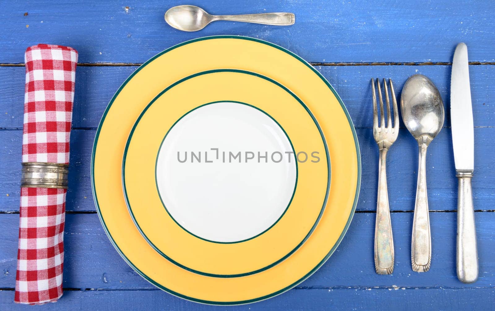plate with silver cutlery on an old blue table