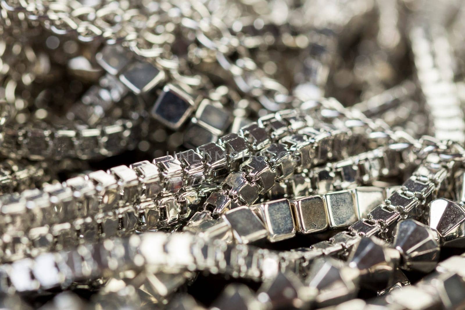 Silver necklace bracelet in brushed metal as close-up on dark background
