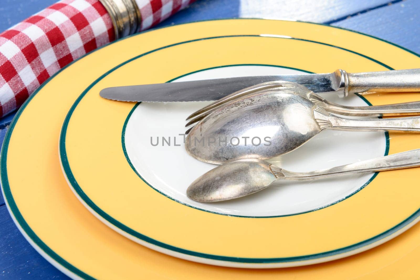 plate with silver cutlery on an old blue table