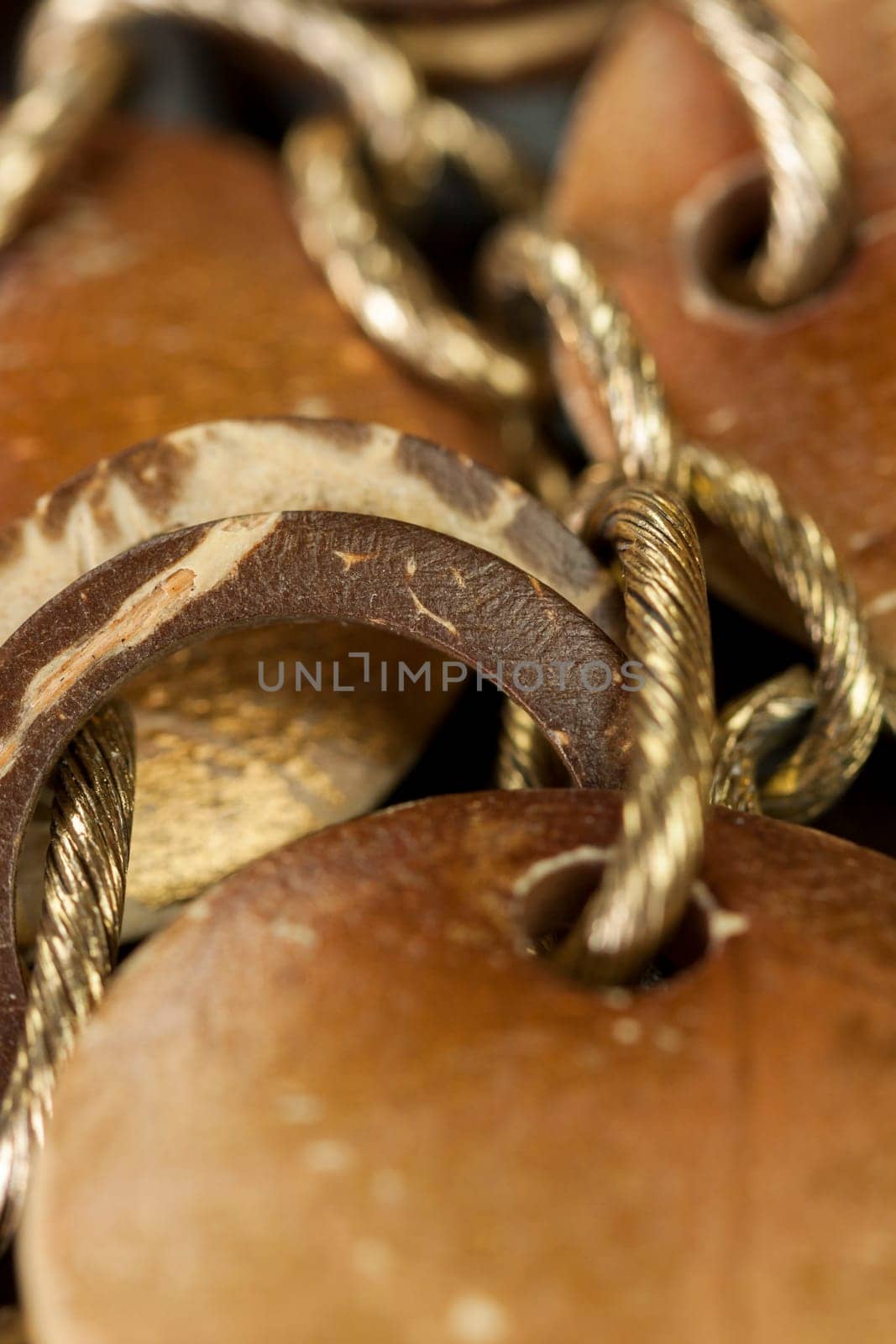 Bracelet or necklace with copper colored round pendants as close-up on dark background