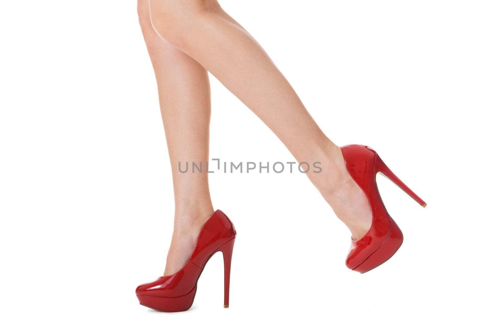 attractive female legs with red stilettos high heels as close-up isolated on white background