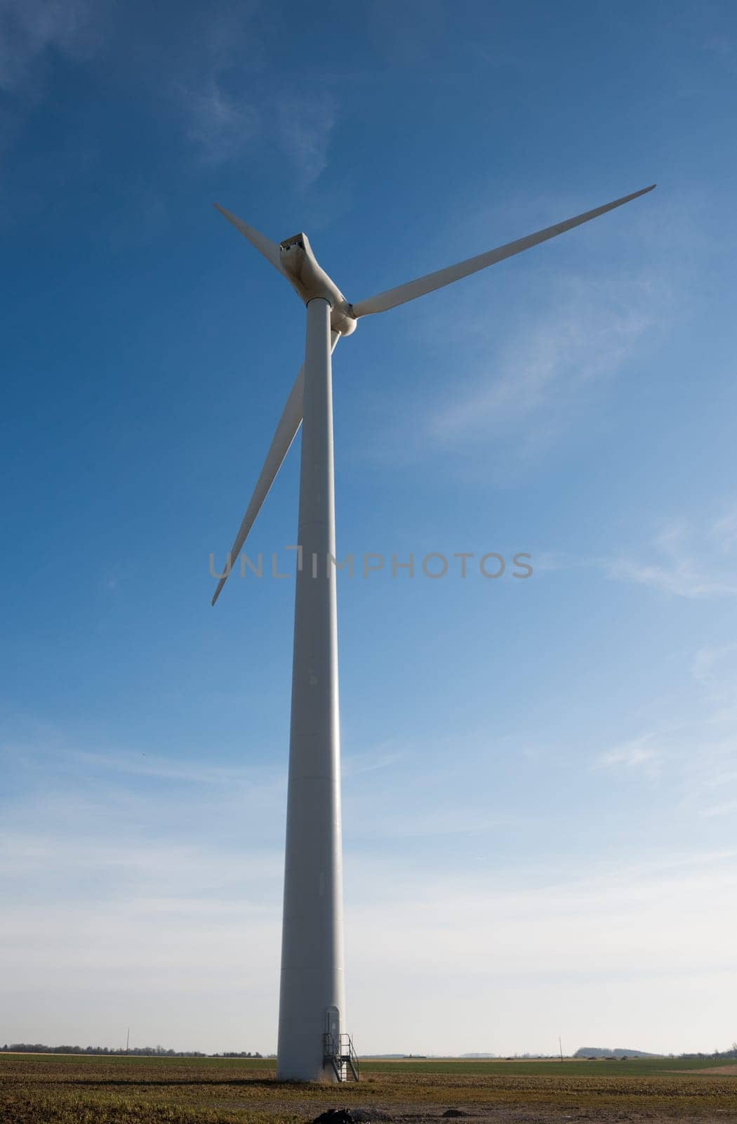 wind turbine on a blue sky with a few clouds