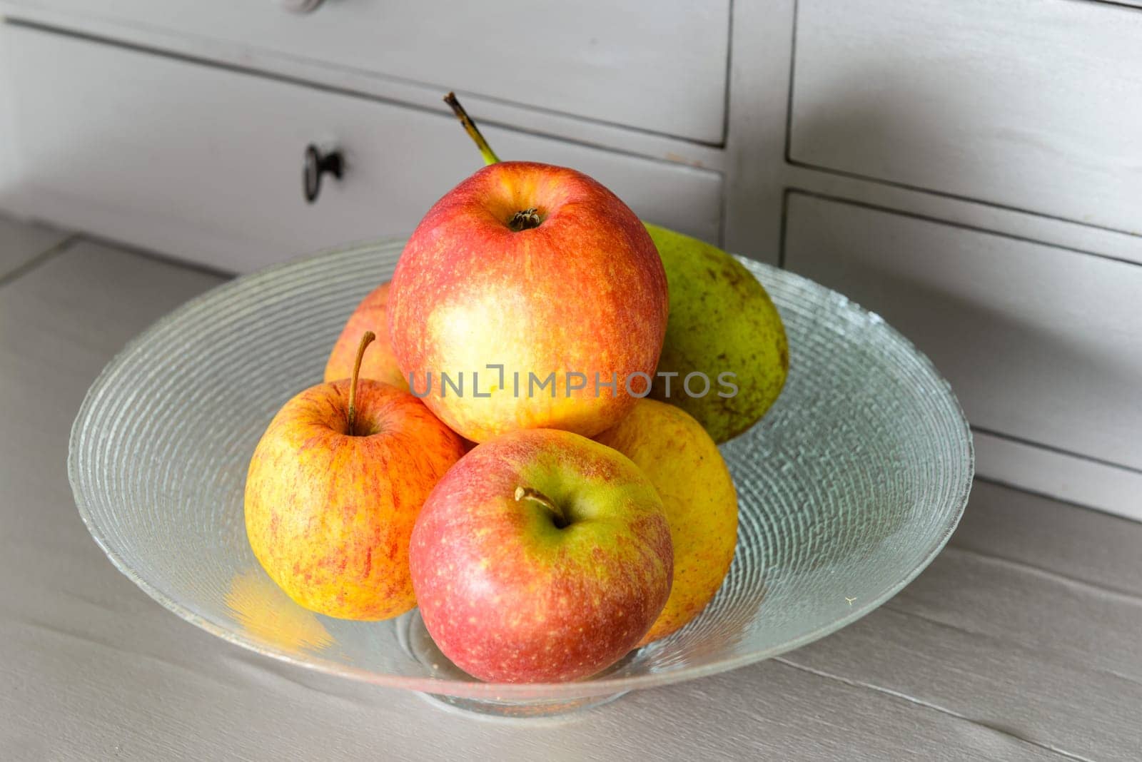 glass cup with red and yellow apples