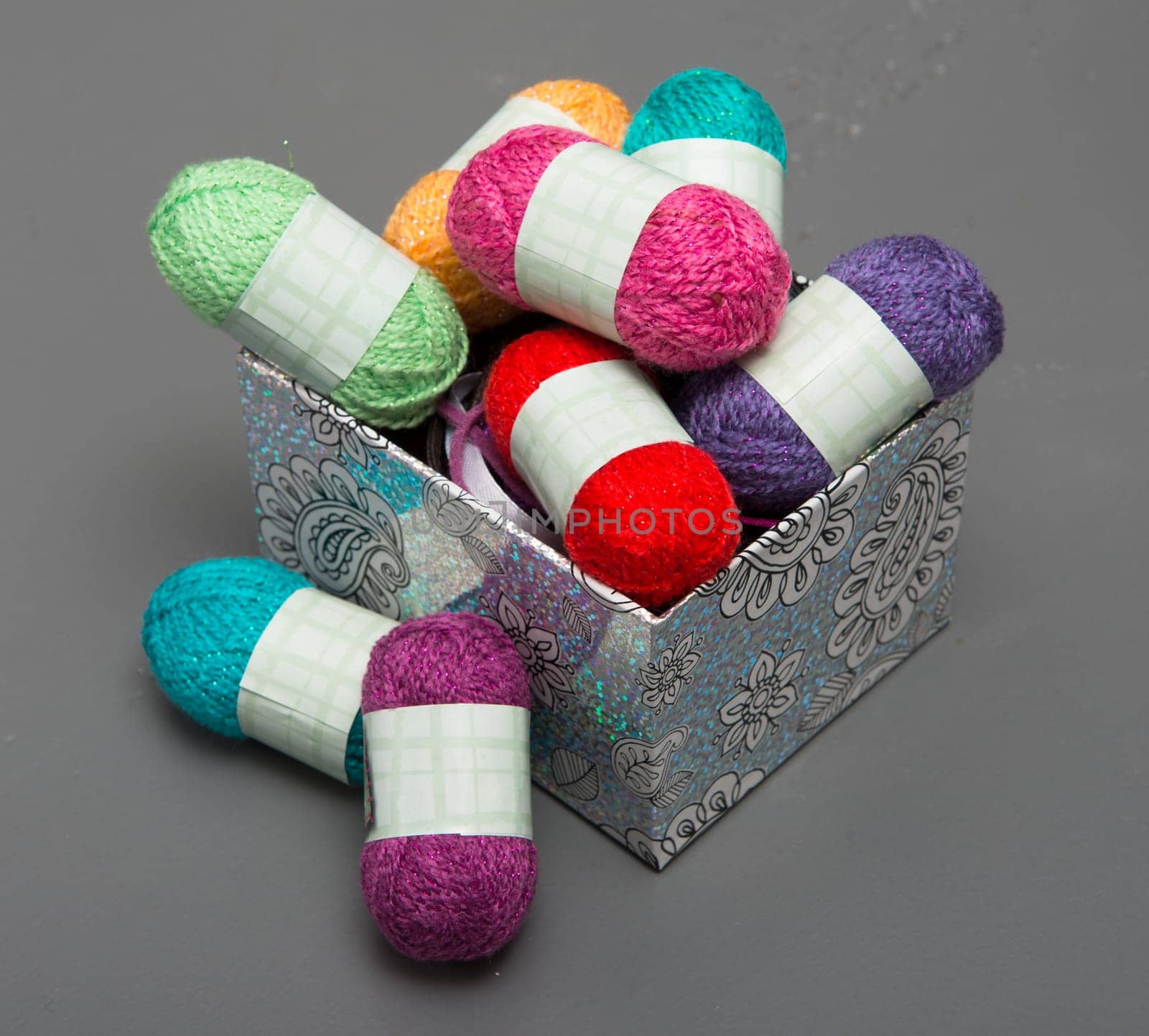 small multicolored balls of yarn on grey table