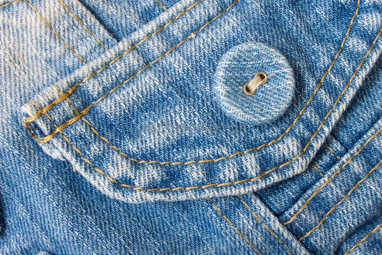 Smart jeans button in classic and pale color. Blue jeans fabric pocket.