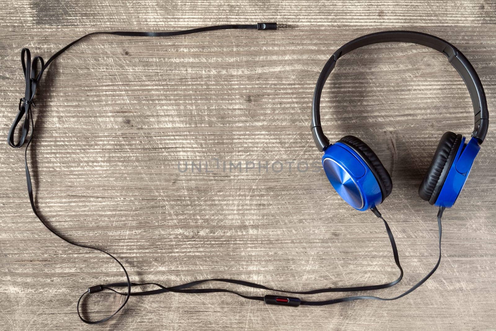 Blue headphones on wooden background with copy-space