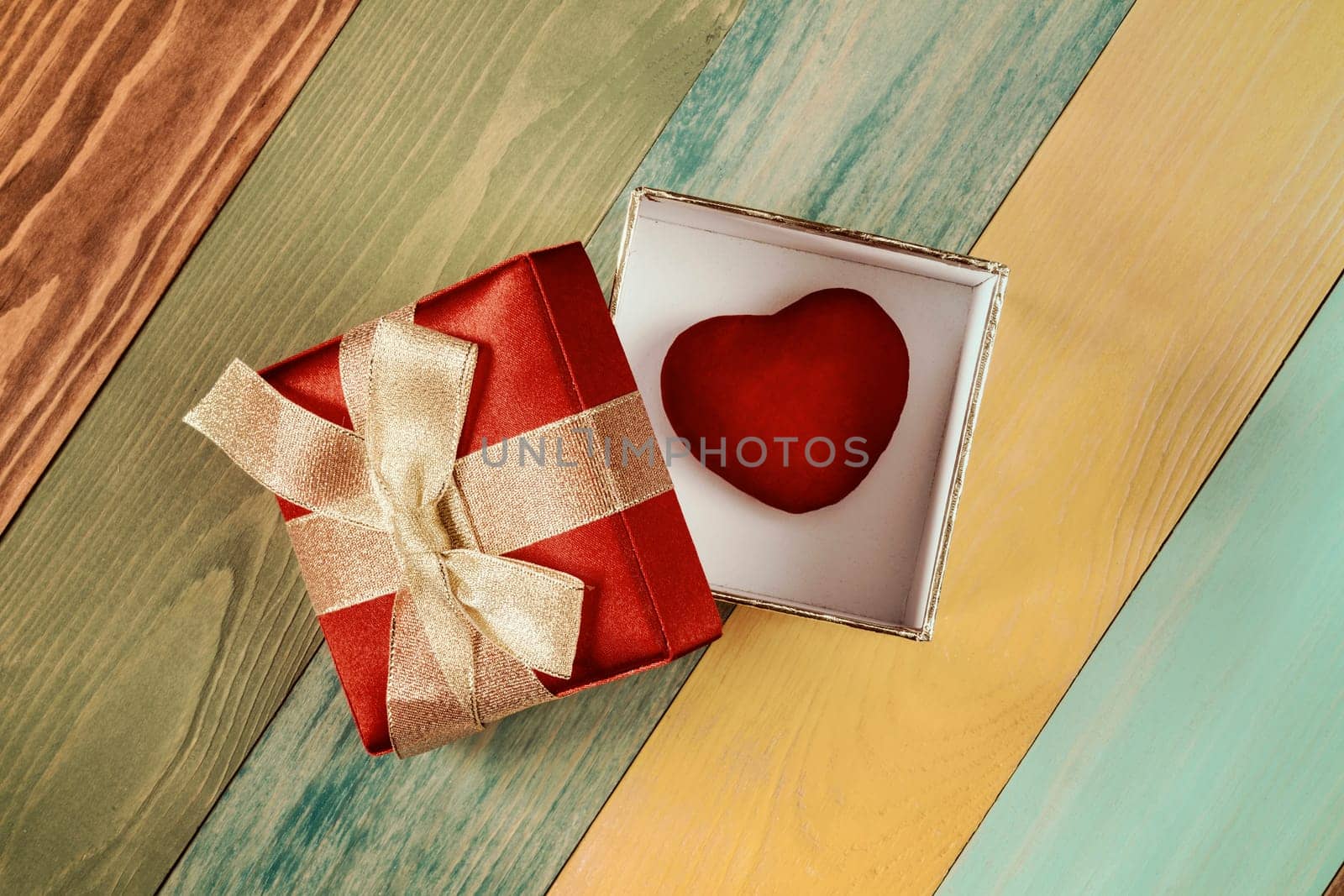 Valentine's day background, gift box with  heart inside on color wooden background