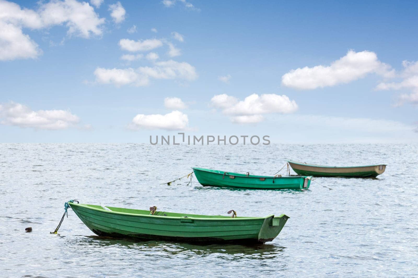 Three wooden boats floating out to sea
