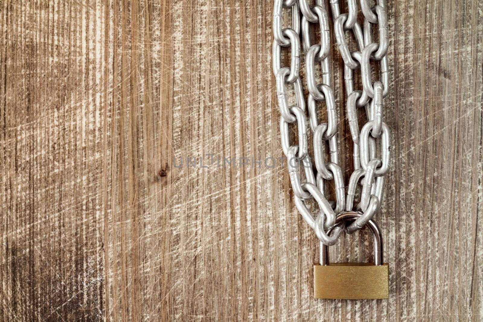 Padlock with chains on the old wooden background